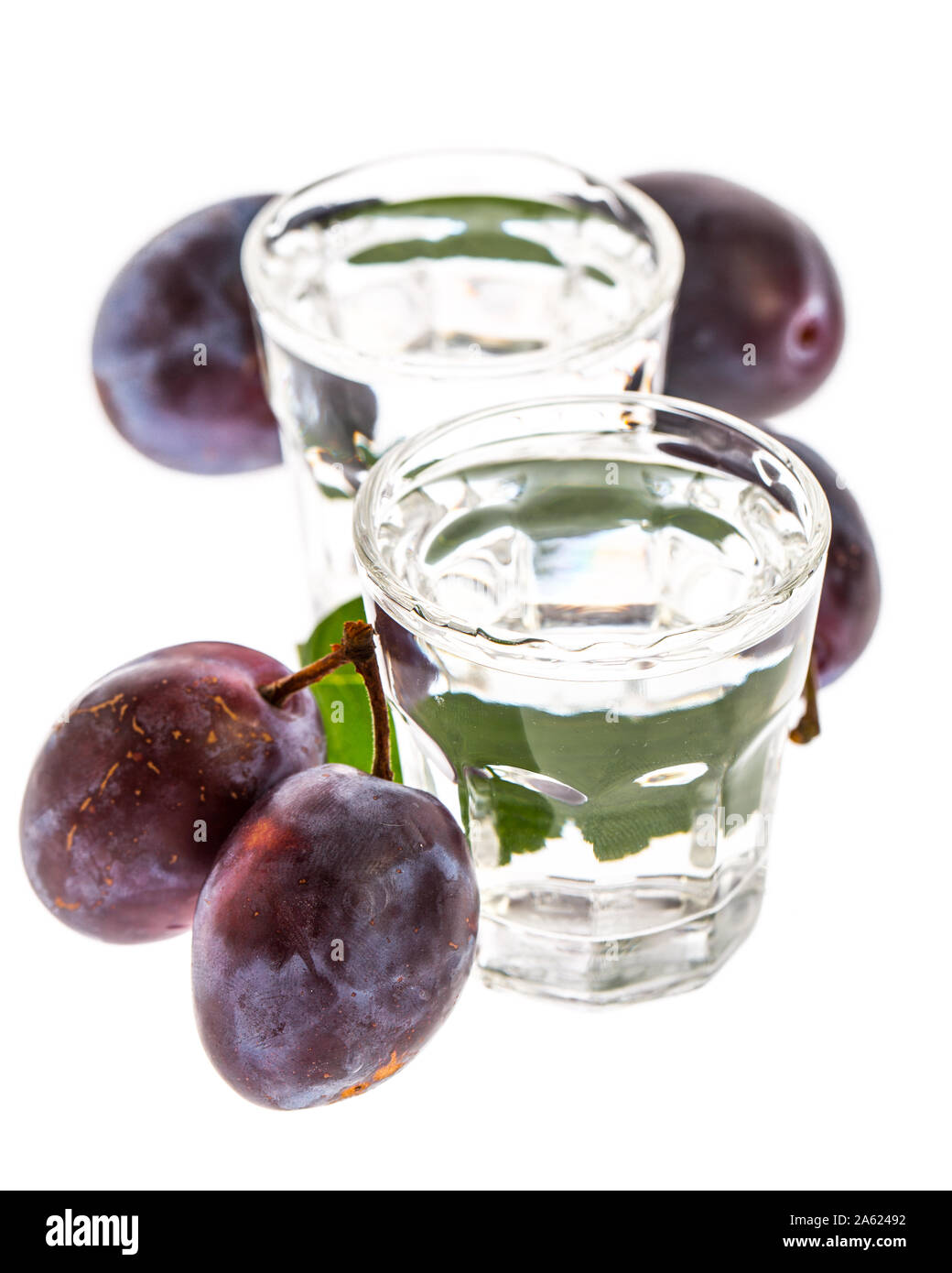 Plum brandy mit Pflaumen auf weißem Hintergrund Stockfoto