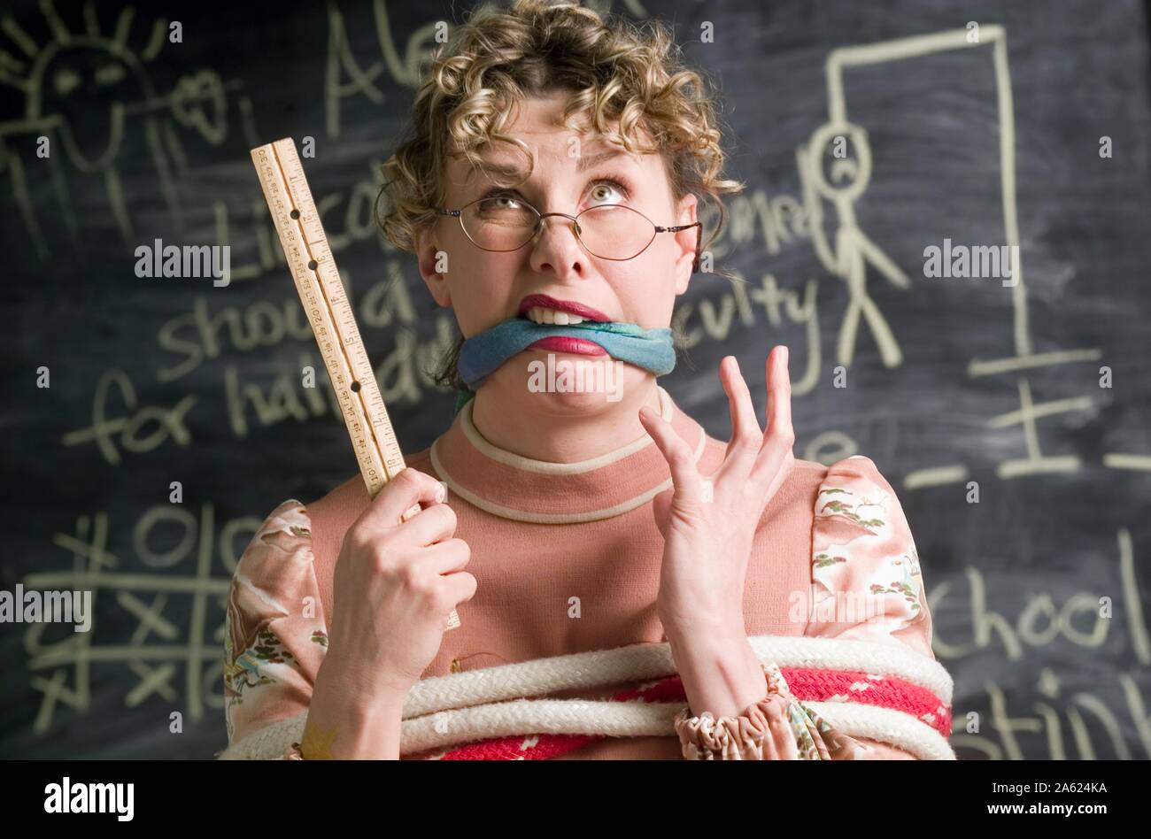 Humorvoll Foto einer Lehrerin vor ihrem Klassenzimmer Tafel gebunden Stockfoto