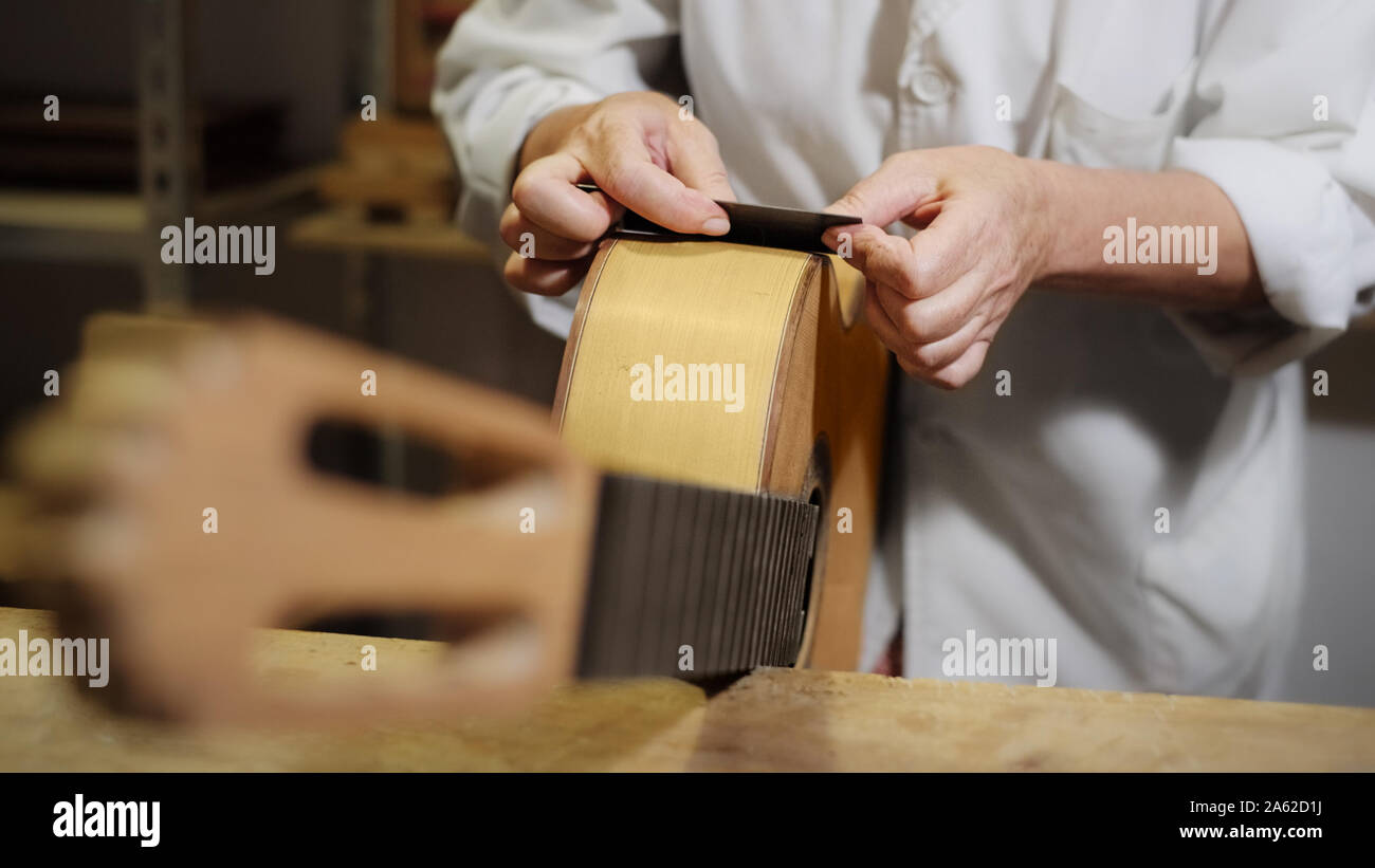 Frau arbeiten als Laute Teekocher Polieren Klassische Gitarre Stockfoto