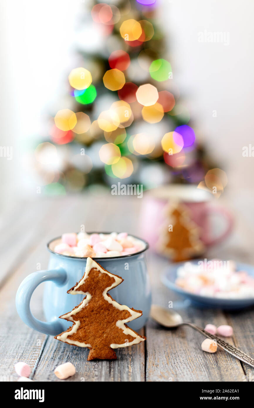 Frohe Weihnachten! Christmas Tree-förmige Lebkuchen Plätzchen in der Nähe von Tassen Kakao und Marshmallows. Schönen unscharfen Weihnachtsbaum Hintergrund mit lumino Stockfoto