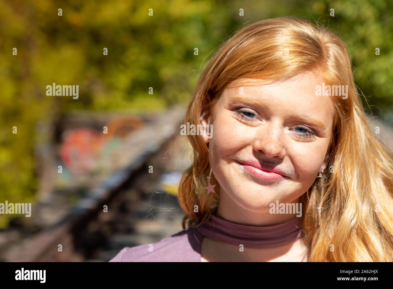 Portrait von wunderschönen Lächeln junges Mädchen mit roten Haaren im Freien auf sonnigen Herbst Tag Stockfoto