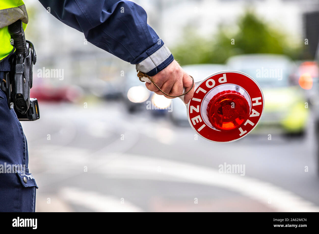 Polizist mit einer gelben Warnweste und ein Stoppen der Pfanne bei einer Verkehrskontrolle, Stockfoto