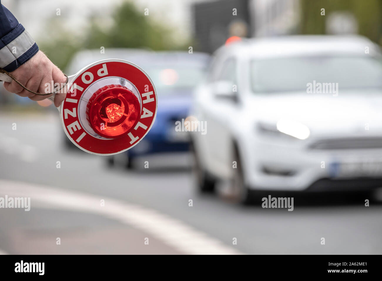 Polizist mit einer gelben Warnweste und ein Stoppen der Pfanne bei einer Verkehrskontrolle, Stockfoto