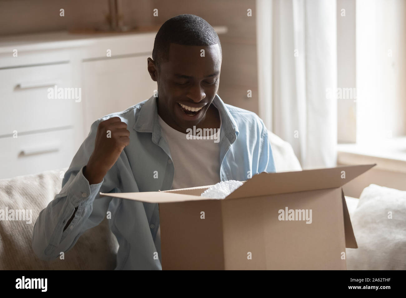 Afrikanische Ethnie lächelnden Kerl mit schnelle einfache Lieferung zufrieden aufgeregt. Stockfoto