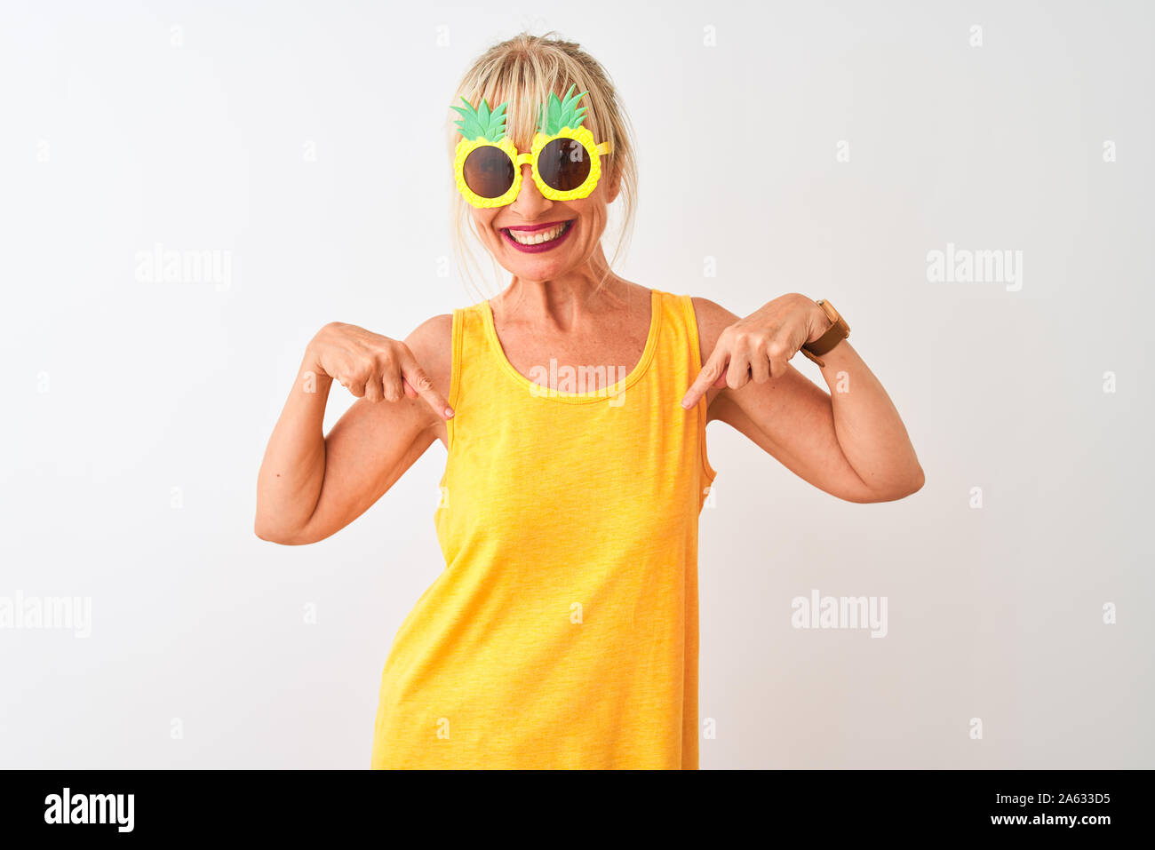 Frau mittleren Alters im Urlaub tragen Ananas Sonnenbrille über isoliert weißer Hintergrund auf der Suche überzeugt mit einem Lächeln auf dem Gesicht, zeigen sich mit f Stockfoto