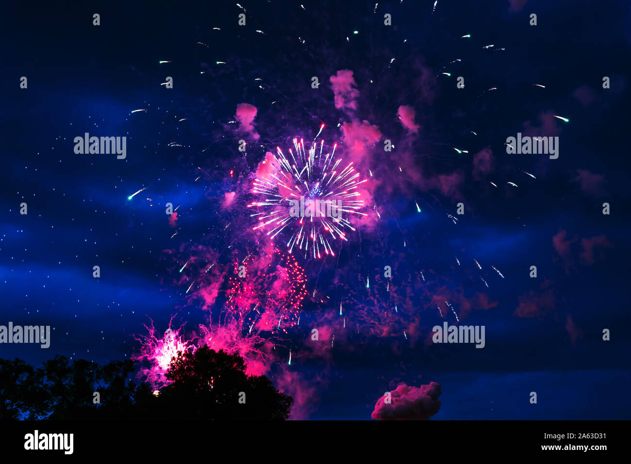 Preiswertes Feuerwerk über der Stadt rot, rosa und weiß. Hell und glänzend. Für jeden Zweck. Feier Konzept. Stockfoto