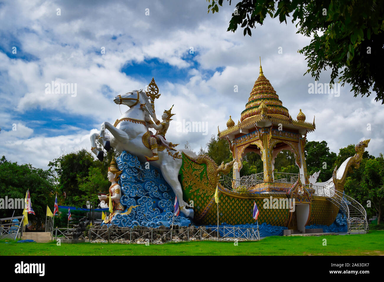 Kanchanaburi, Thailand 08.17.2019: Statue der Gottheit, Gott oder eine Göttin, eine detaillierte, kunstvoll White Horse dekoriert Tracking ein goldenes Boot am Wat Stockfoto