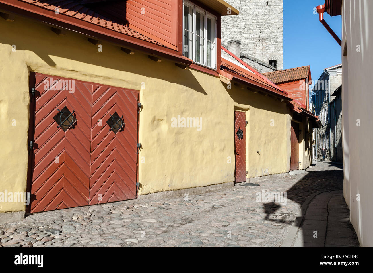 Straße in der Altstadt mit bunten Häusern mit Blick auf einen der Türme der mittelalterlichen Mauer rund um die Stadt Stockfoto