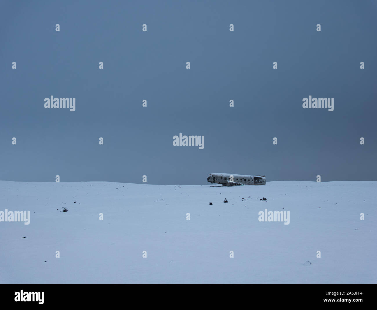 Abgestuerztes Flugzeug auf eine schneebedeckte Wiese in Island Stockfoto