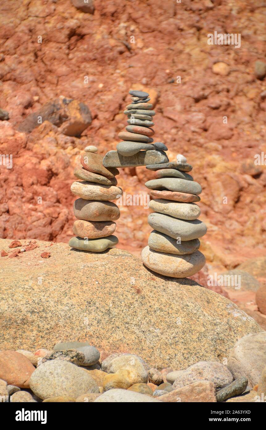 Mehrere kleine Steine, in einem perfekt ausgewogenen Cairn auf einem großen Felsblock gestapelt. Stockfoto
