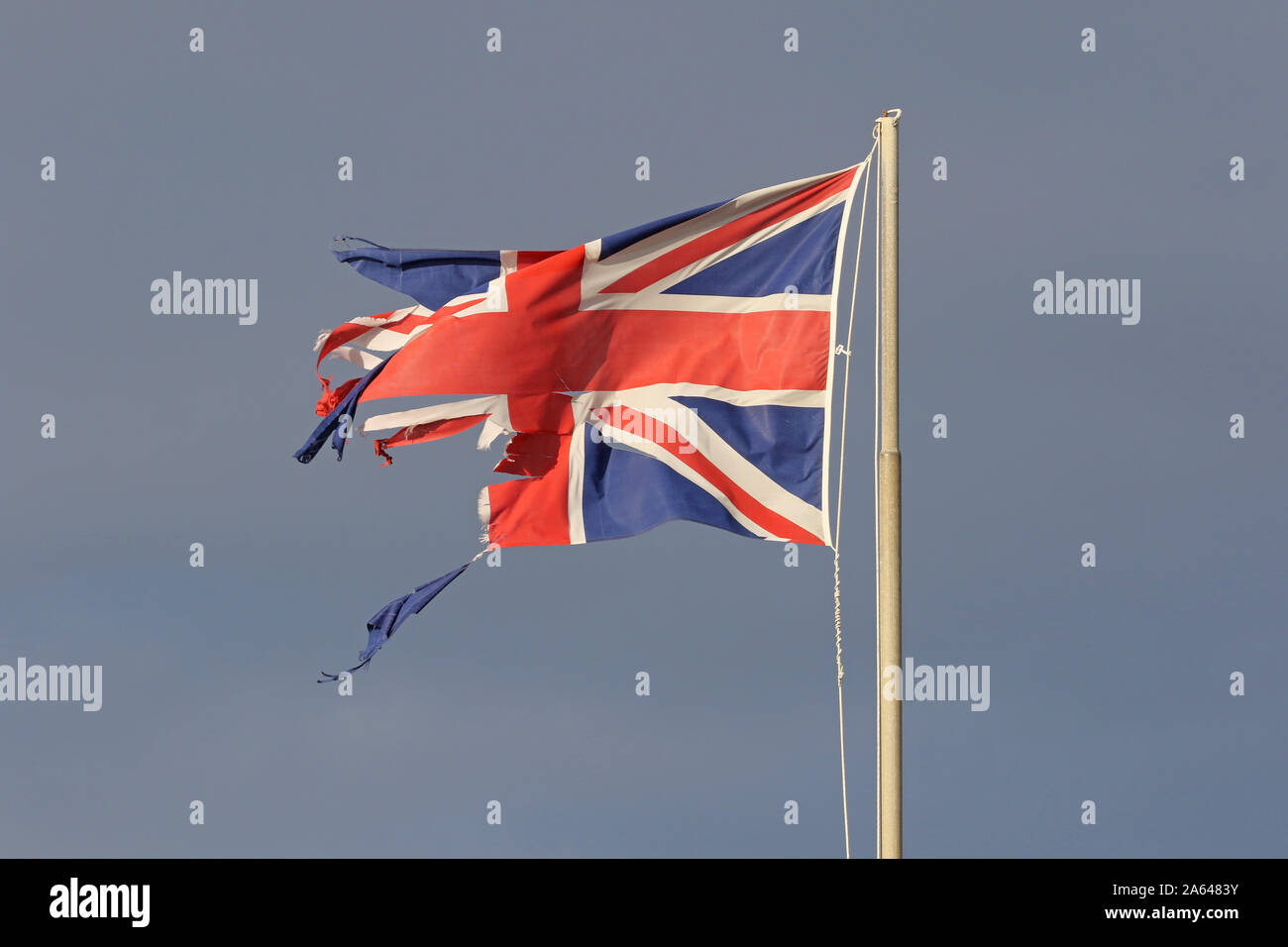 Britische Flagge oder Union Jack zerrissenen und zerfetzten Fliegen im Winter am Meer in Italien, die die Katastrophe von Brexit Stockfoto