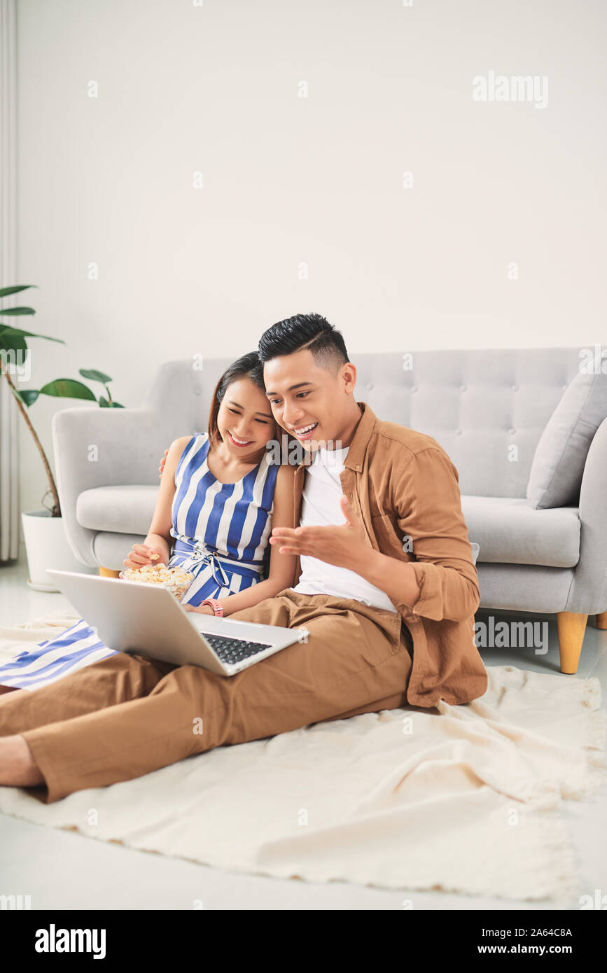 Jungen asiatischen Paar ein Video ansehen auf dem Laptop im Wohnzimmer Stockfoto