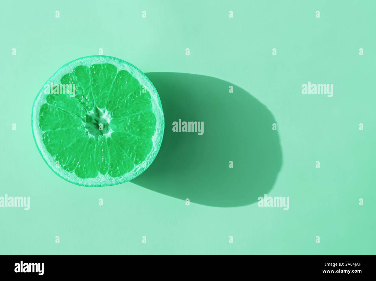 Die Hälfte der Zitrusfrüchte im Sonnenlicht getönten in mint Farbe Stockfoto