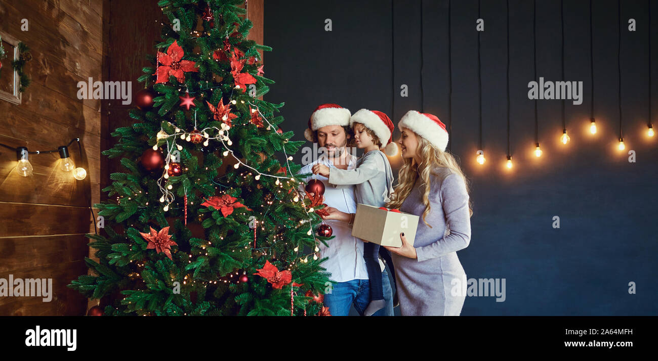 Familie schmückt den Weihnachtsbaum zu Hause in Weihnachten Stockfoto