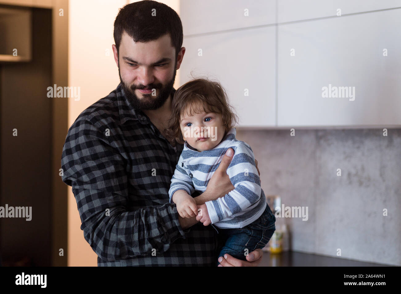 Vater Holding 8-Monate alten Sohn, ihm saures Aufstoßen nach dem Füttern. Stockfoto