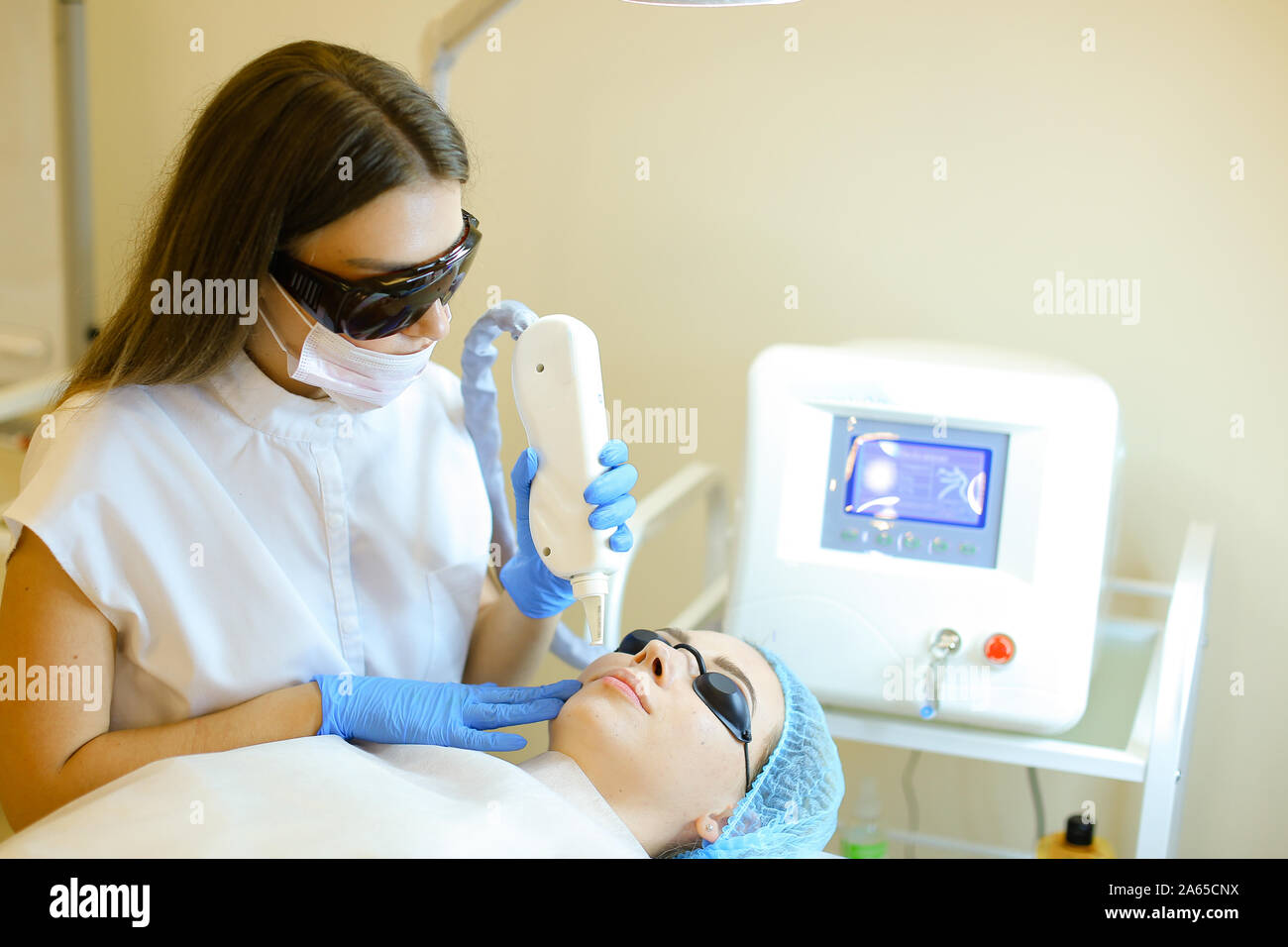 Qualifizierte Kosmetikerin Permanent Make-up entfernen mit Laser für junge Mädchen. Stockfoto