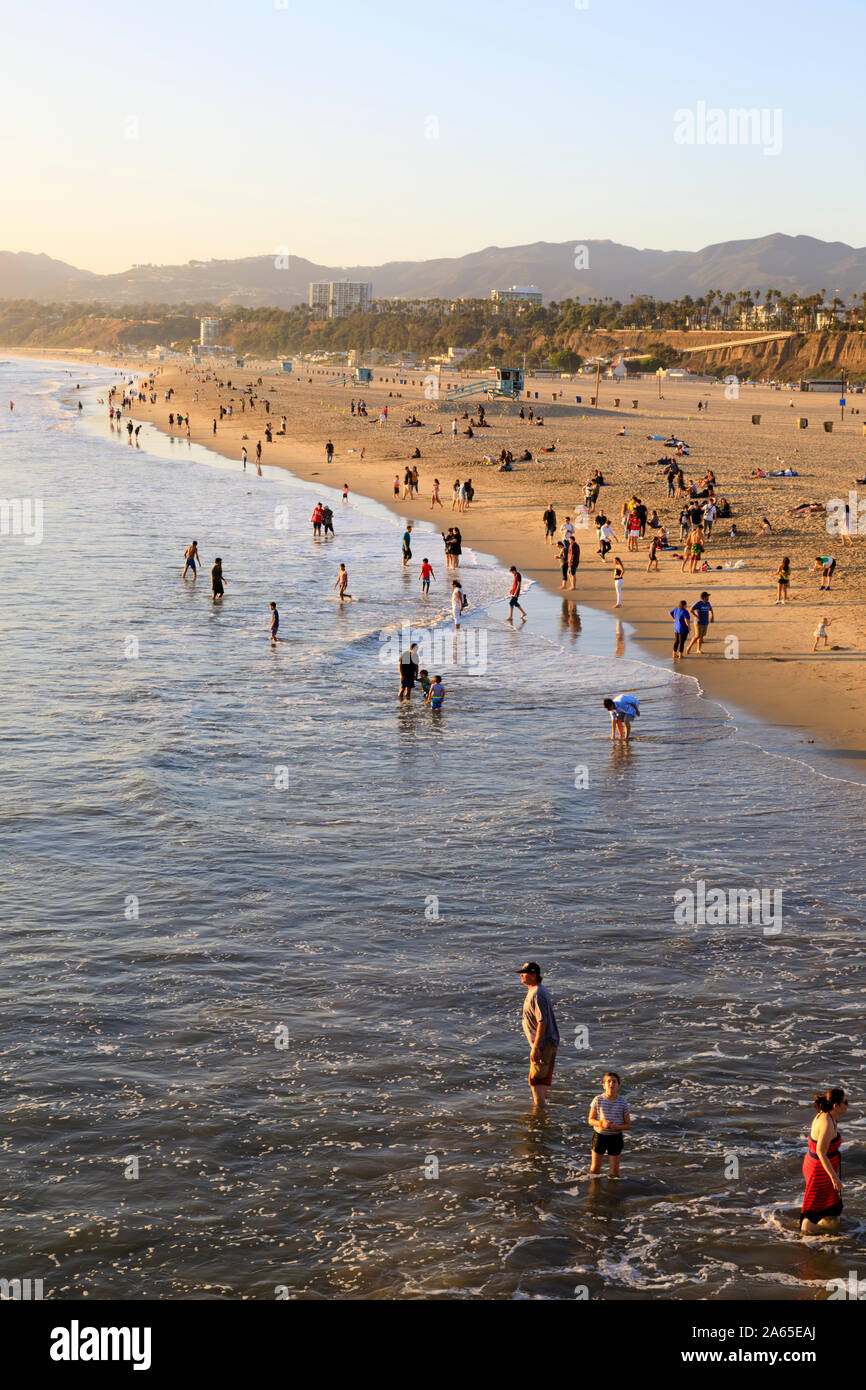Badende am Strand von Santa Monica eine letzte Schwimmen, bevor die Sonne untergeht. Los Angeles, Kalifornien, Vereinigte Staaten von Amerika. Oktober 2019 Stockfoto