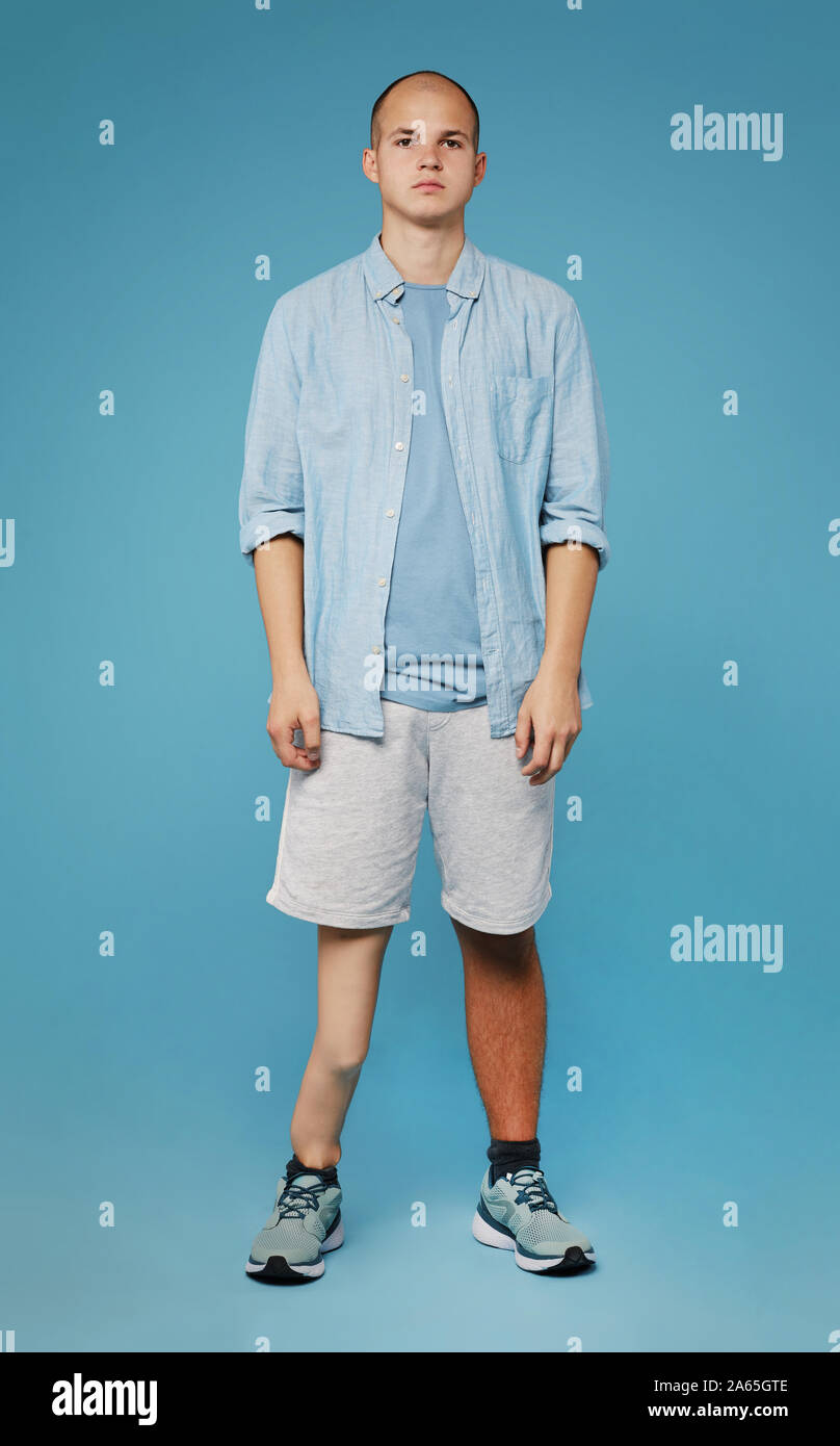 Porträt der jungen Teenager mit Bein Prothese in Freizeitkleidung auf blauem Hintergrund Stockfoto
