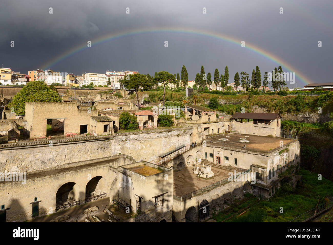 Ercolano. Italien. Regenbogen über den archäologischen Ausgrabungen von Herculaneum mit der alten Küstenlinie im Vordergrund. Stockfoto