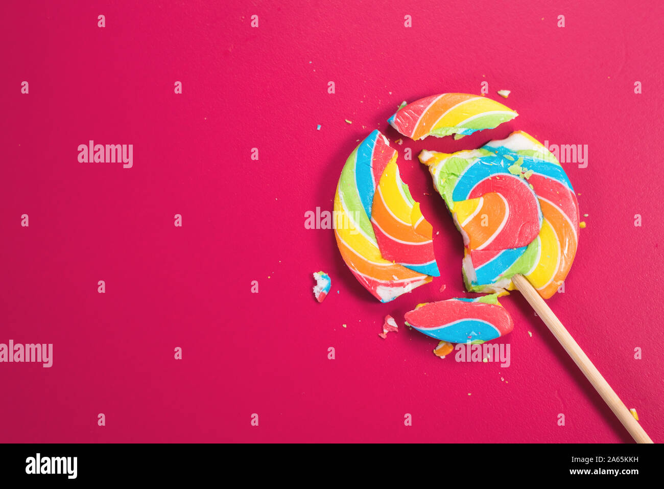 Swirl Runde abgebrochen Lollipop auf rosa Hintergrund. Konzept der ungesunde Nahrungsmittel, Süßwaren und Süßigkeiten Tag Stockfoto