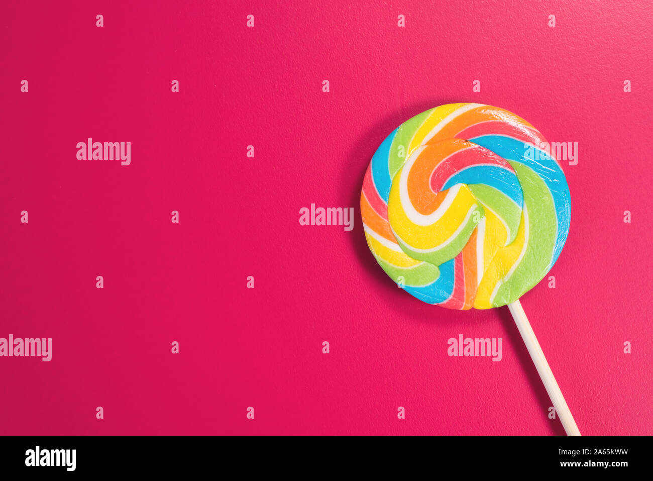 Swirl runde Lutscher auf rosa Hintergrund. Konzept der ungesunde Nahrungsmittel, Süßwaren und Süßigkeiten Tag Stockfoto