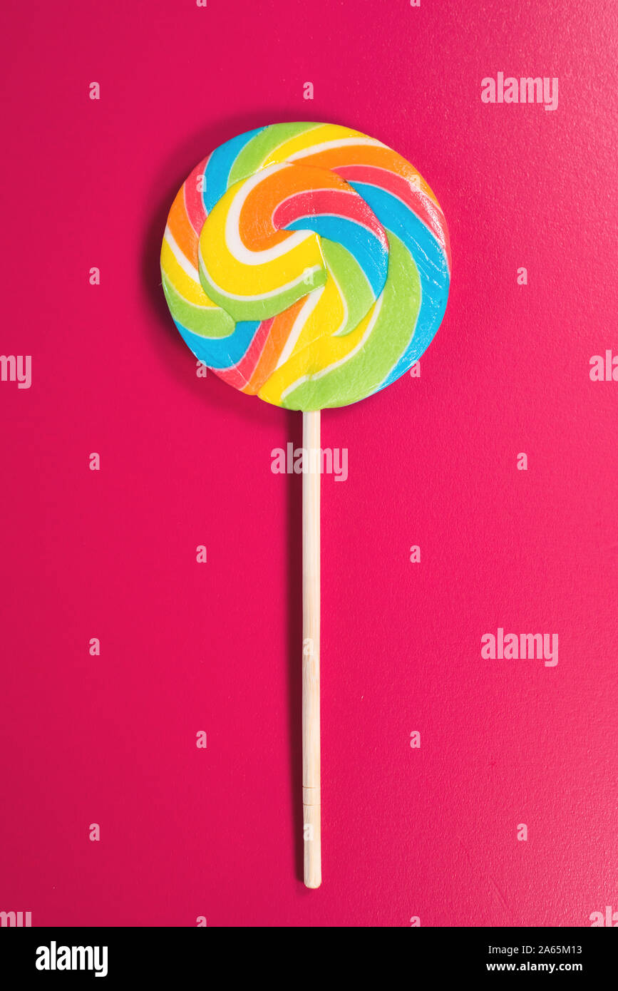 Swirl runde Lutscher auf rosa Hintergrund. Konzept der ungesunde Nahrungsmittel, Süßwaren und Süßigkeiten Tag Stockfoto