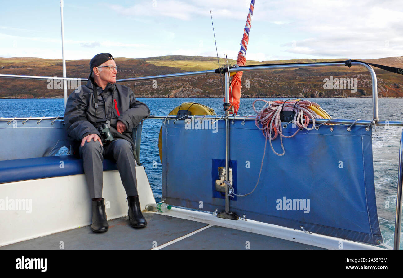 Ein älterer Mann auf einem Wildlife Bootsfahrt in den Klang der Raasay von Portree auf der Insel Skye, Schottland, Großbritannien, Europa. Stockfoto