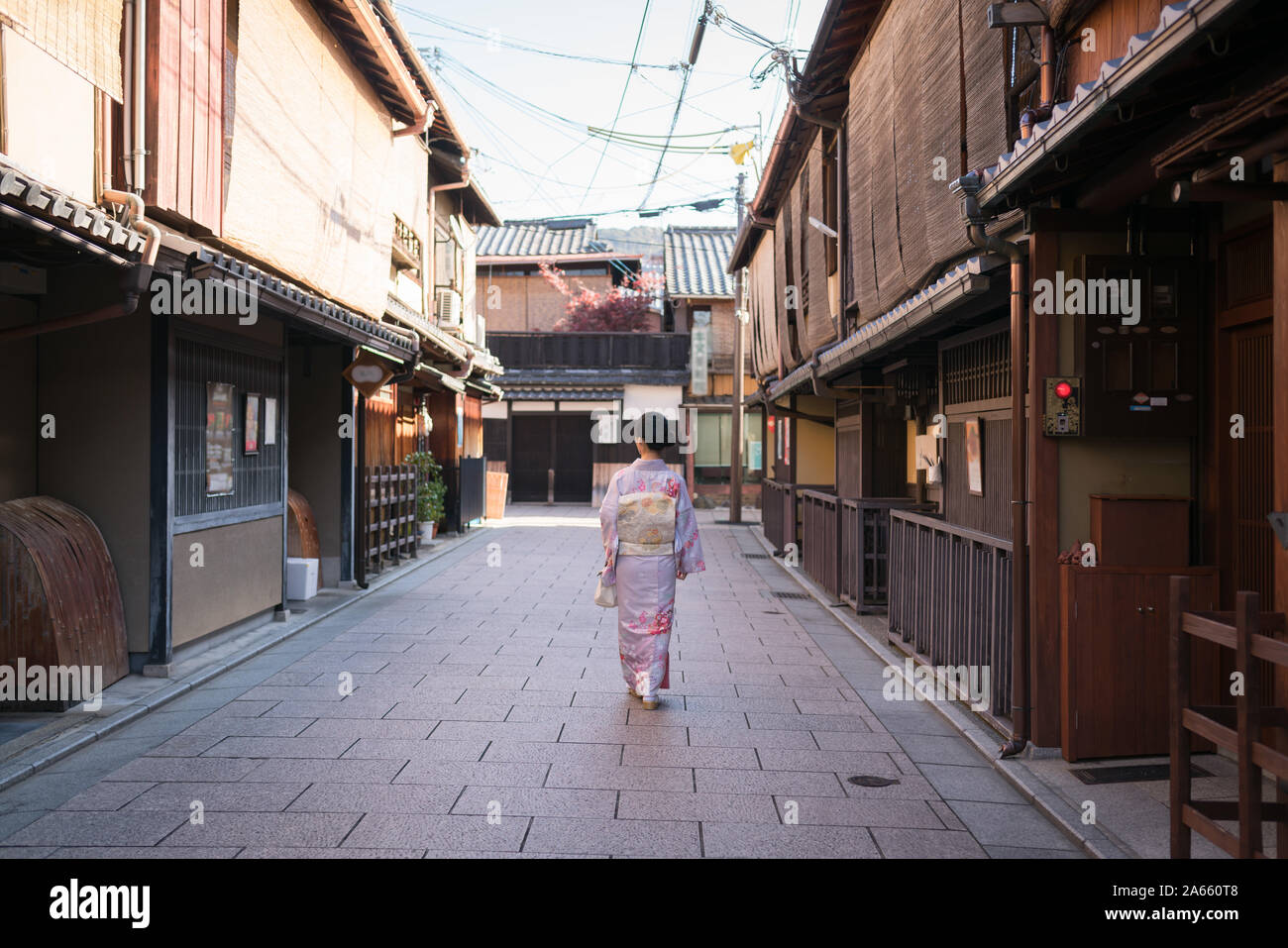 Junge Asiatische Dame im Kimono zu Fuß in eine leere Straße in Higahiyama Bezirk, Gion, Kyoto, Japan Stockfoto