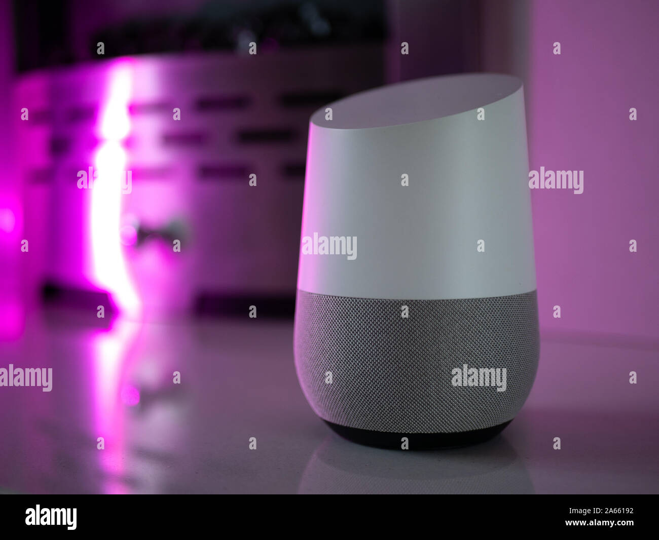 Smart Home Lautsprecher Assistant auf Kamin mit LED-farbiges Umgebungslicht - Rosa Stockfoto