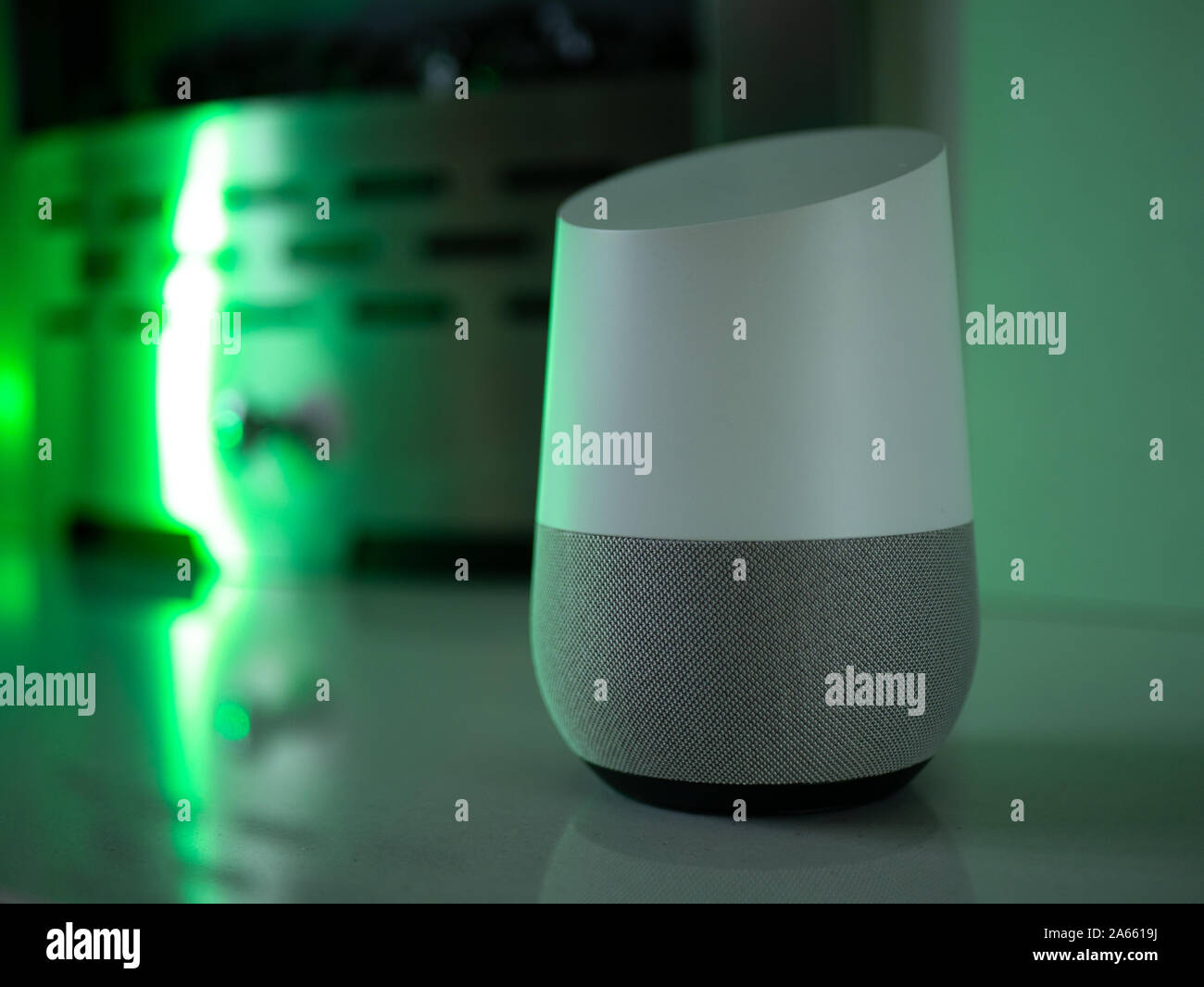 Smart Home Lautsprecher Assistant auf Kamin mit LED-farbiges Umgebungslicht - Grün Stockfoto