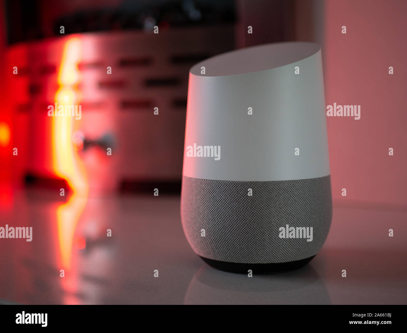 Smart Home Lautsprecher Assistant auf Kamin mit LED-farbiges Umgebungslicht - Rot Stockfoto