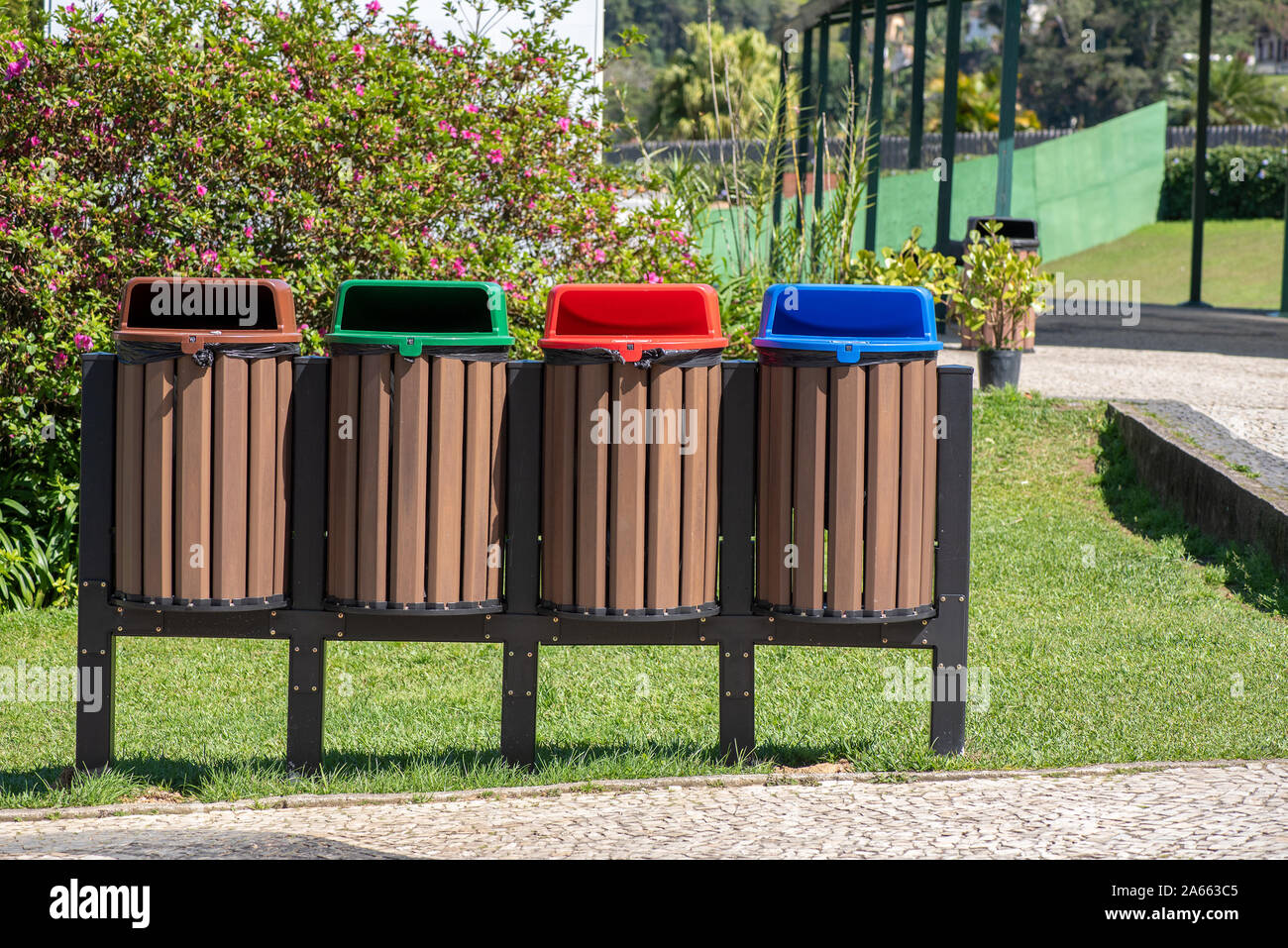 Vier recycling Bins in den Farben Rot, Blau, Grün, Braun, in einem öffentlichen Park, draußen, Vorderansicht, keine Logos Stockfoto
