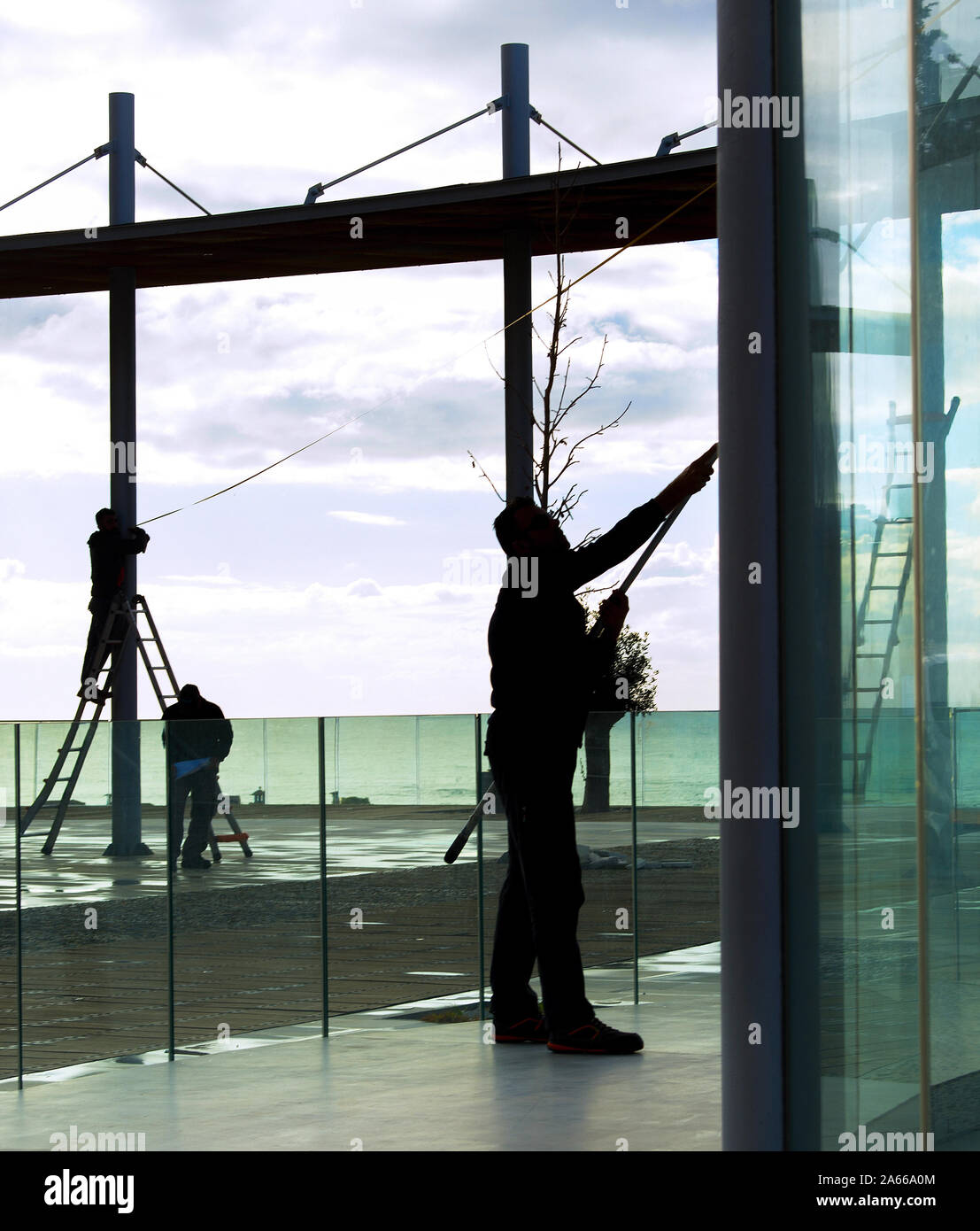 Silhouetten der Arbeitnehmer reinigen Glas Konstruktionen im modernen Sicht, Paphos, Zypern Stockfoto