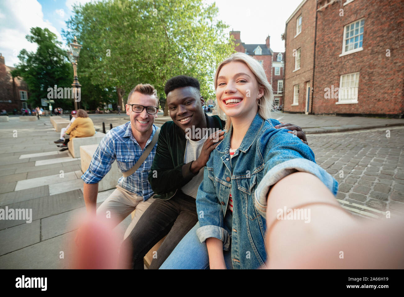 Ein selfie Schuß von zwei Männer und eine Frau, die Frau ist unter Berücksichtigung der selfie. Stockfoto