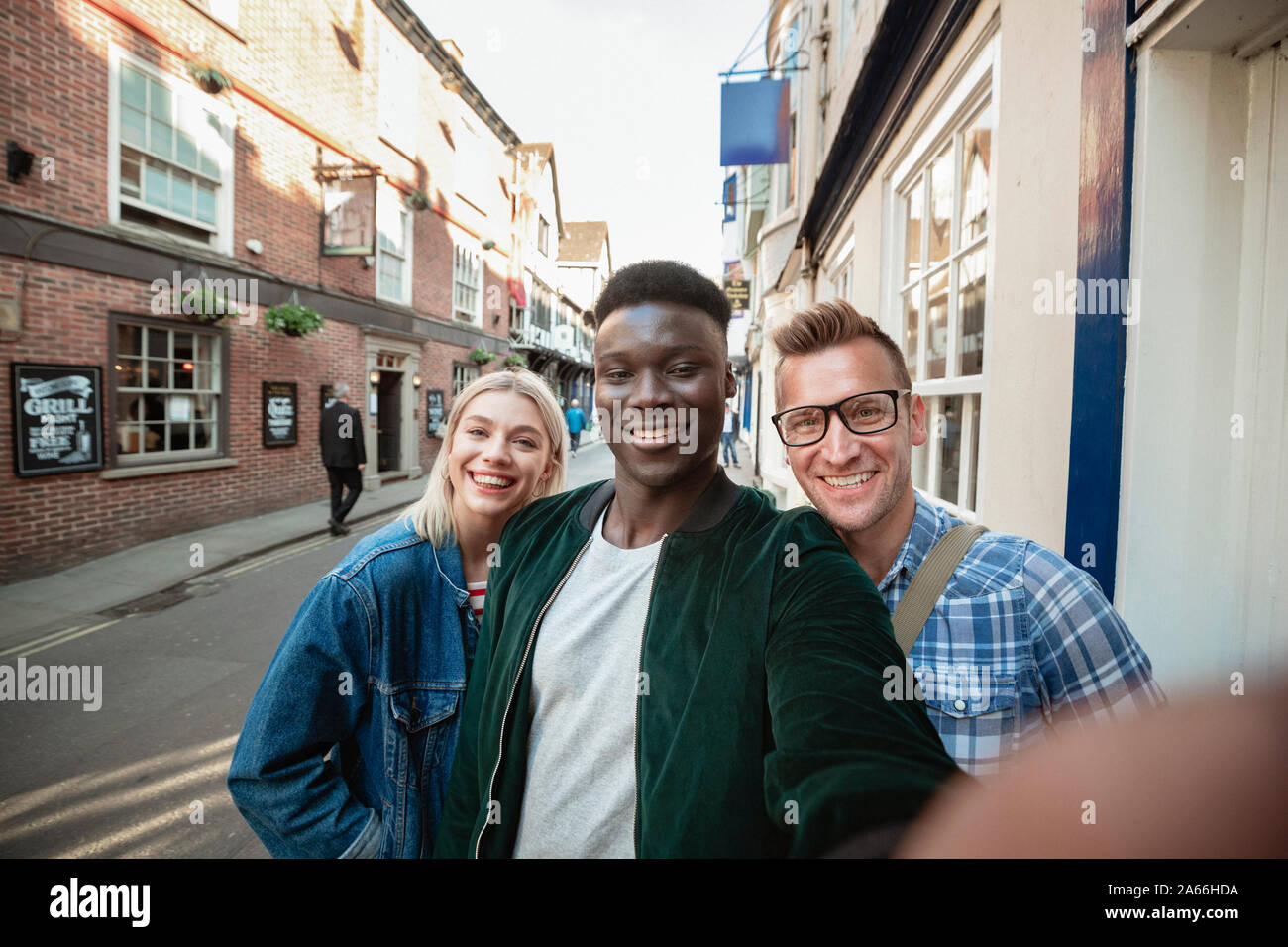 Ein selfie Schuß von zwei Männer und eine Frau auf einer Straße der Stadt. Sie lächeln in die Kamera. Stockfoto