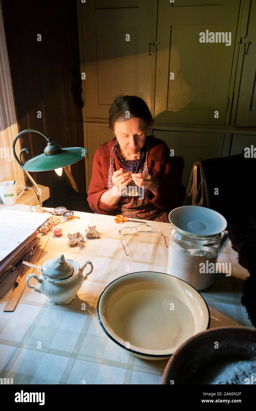 Frau, die Handarbeit in einem Bauernhaus. Estnische Freilichtmuseum Rocca Al Mare. Tallinn, Estland Stockfoto