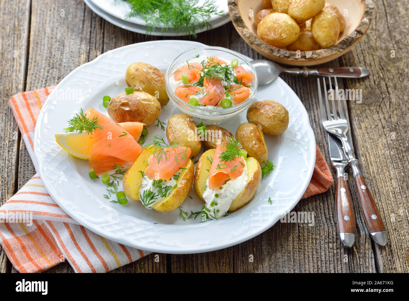 Baby jacke Kartoffeln frisch aus dem Ofen serviert mit Kraut Quark und geräuchertem Lachs Stockfoto