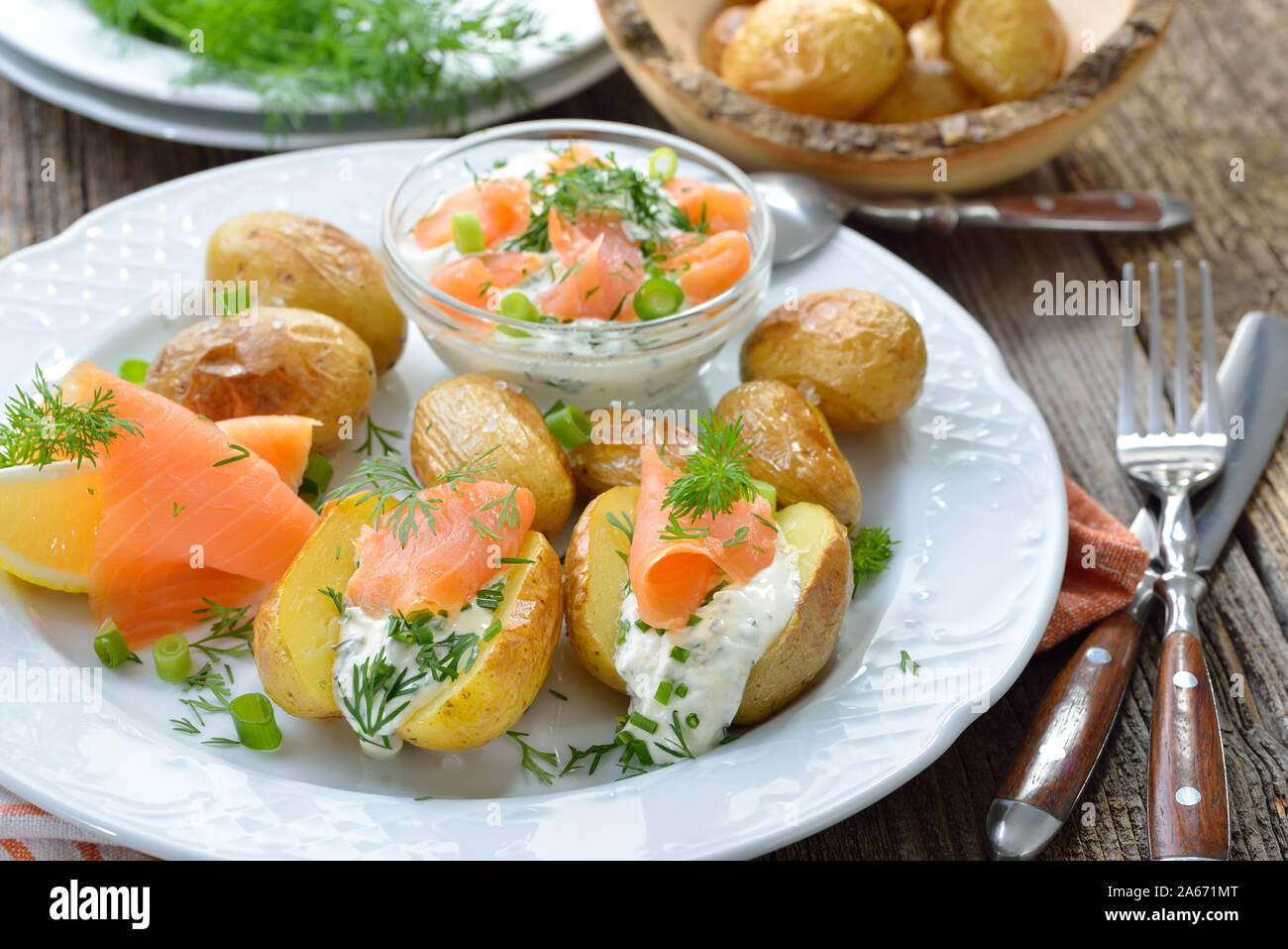 Baby jacke Kartoffeln frisch aus dem Ofen serviert mit Kraut Quark und geräuchertem Lachs Stockfoto
