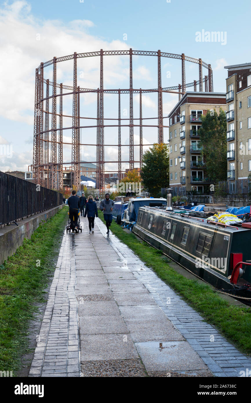 Der Leinpfad entlang der Regent's Canal in der Nähe der Katzen- und Hammelfleisch Brücke mit leeren Gasometer, Hackney, East London, London, Großbritannien, Europa Stockfoto