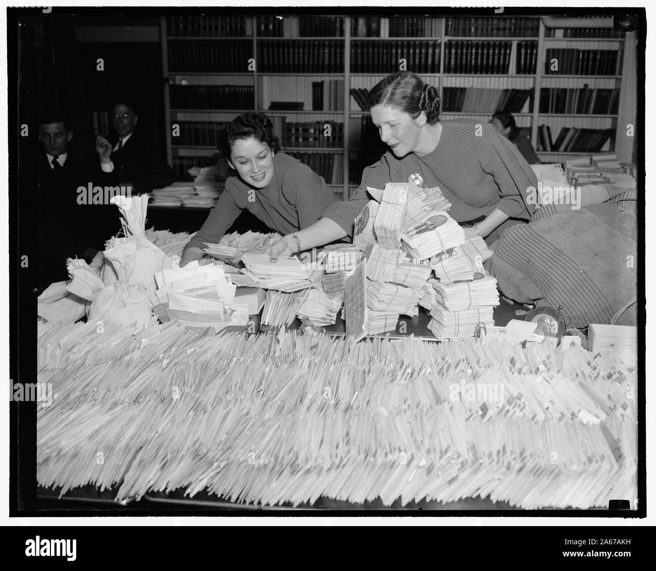 Weiße Haus überflutet mit Groschen für Lähmung zu kämpfen. Washington, D.C., 31.01.25. Barbara Ratsmitglied und Ethel Haberkorn, Arbeiter im Weißen Haus Mail Zimmer, versucht, mit der Flut der Groschen, die der Präsident Geburtstag Ball Ausschuss kommen an den Fonds zu Recht die Kinderlähmung hinzuzufügen, 1-25 - 39 zu halten. Stockfoto