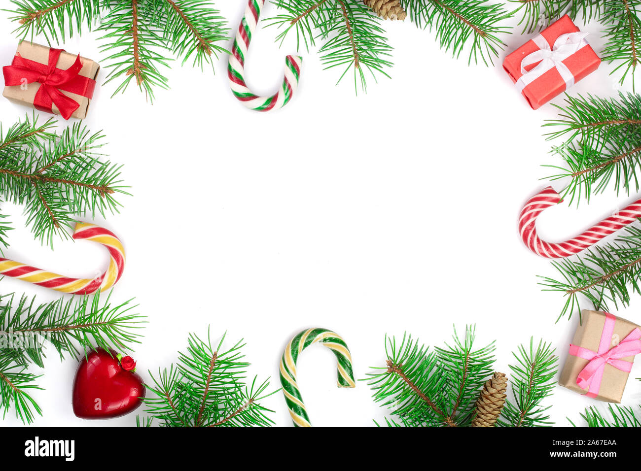 Weihnachten Rahmen der Fir Tree Branch mit Zuckerstangen und Boxen auf weißem Hintergrund mit Kopie Platz für Ihren Text isoliert. Ansicht von oben. Stockfoto
