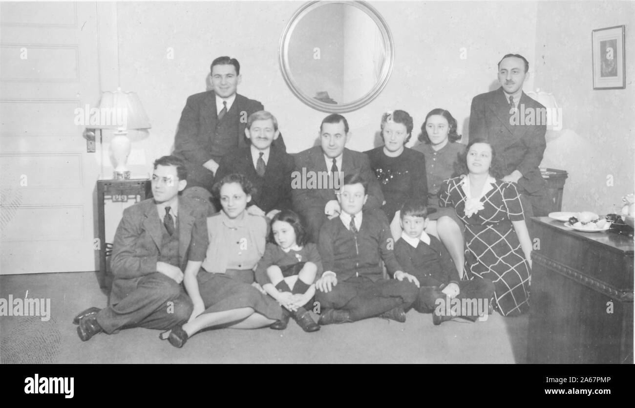 Große, mehrgenerationenübergreifende, judenamerikanische Familie stellt sich in ihrem Wohnzimmer in New York City, New York, 1940. () Stockfoto