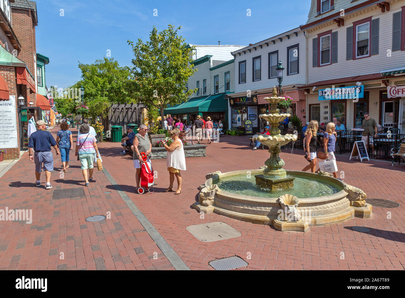 Kunden, Freunden, Touristen zu Fuß in einer Einkaufsstraße, reden, lachen und gehen in den Geschäften an einem schönen Tag. Stockfoto