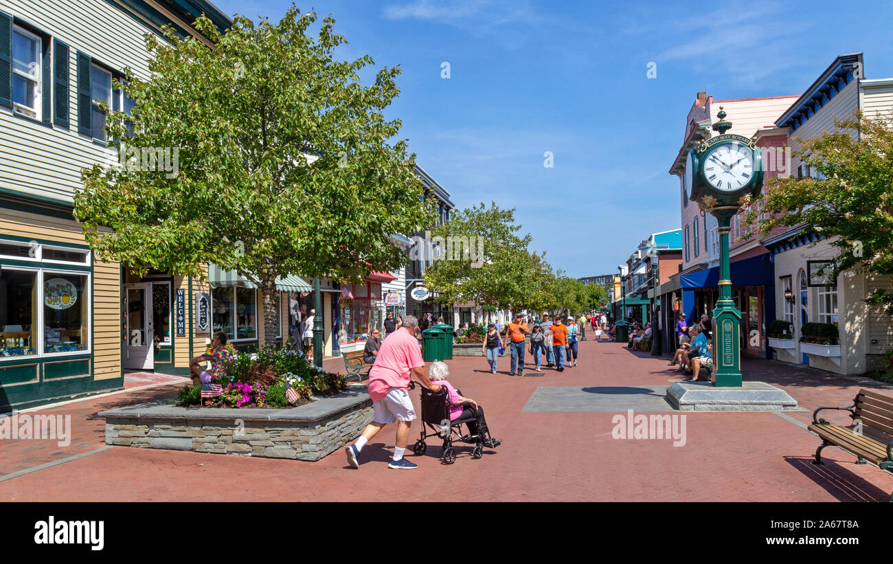 Kunden, Freunden, Touristen zu Fuß in einer Einkaufsstraße, reden, lachen und gehen in den Geschäften an einem schönen Tag. Stockfoto
