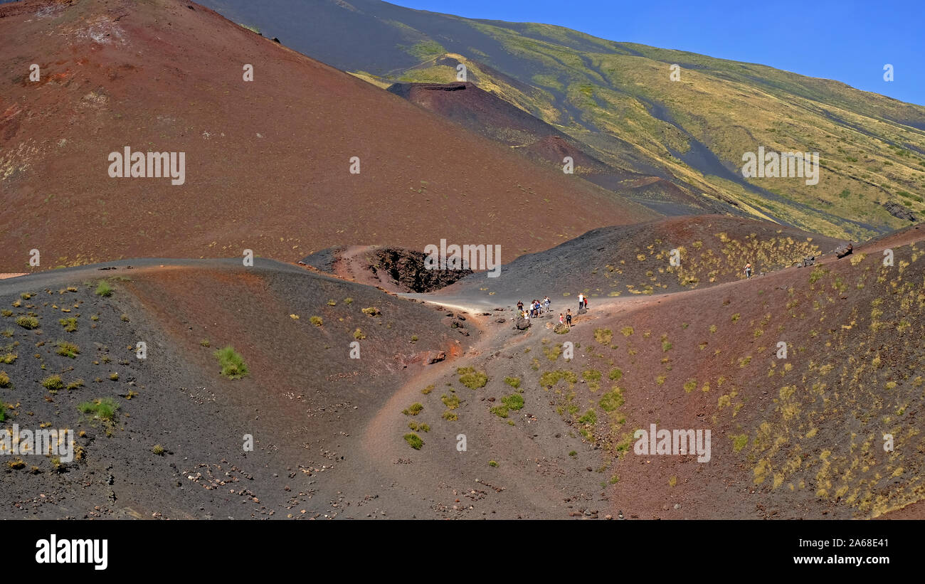 Touristen wandern durch die vulkanische Landschaft der Krater Silvestri des Ätna (Vulkan), Sizilien, Italien. 8/3/2019. Stockfoto