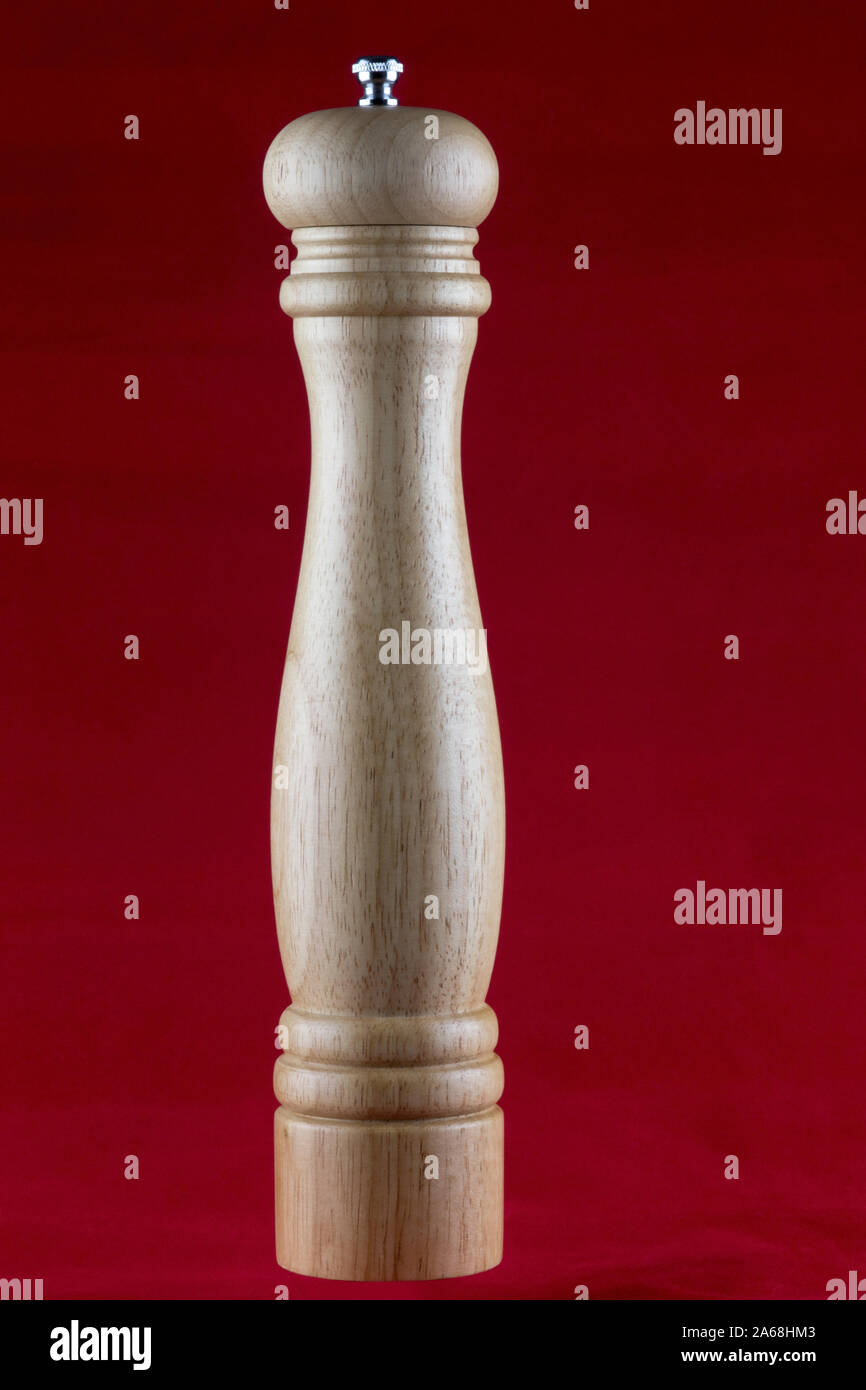 Holz- Pfeffer Schleifer auf einer roten Tischdecke isoliert Stockfoto