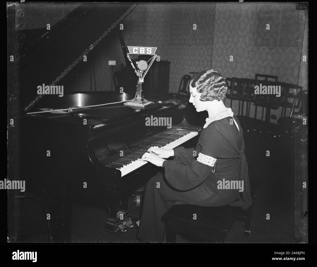 Frau Klavier spielen mit CBS Mikrofon Stockfoto