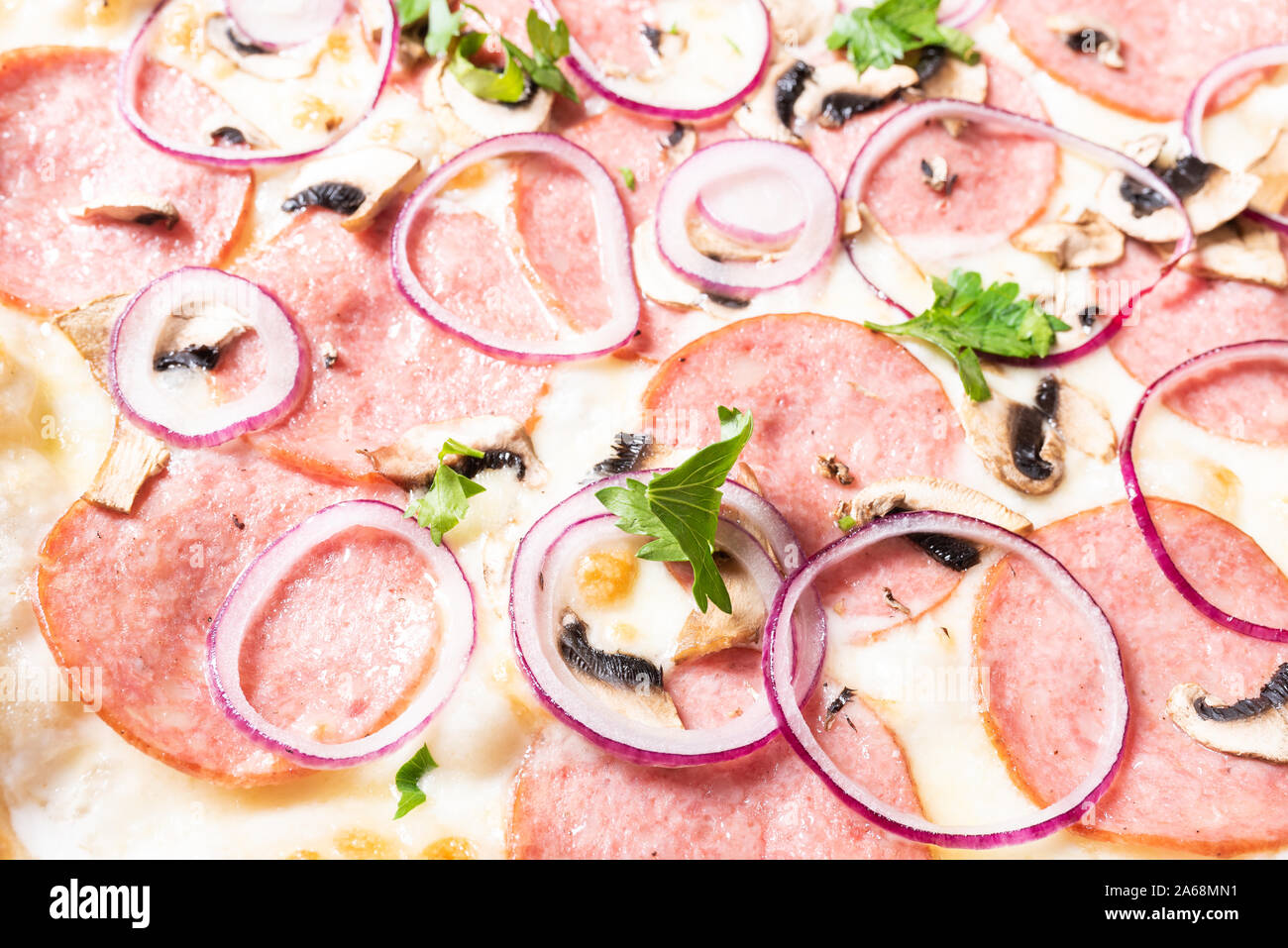 Billige Pizza mit Salami, Zwiebeln und Pilze. Stockfoto