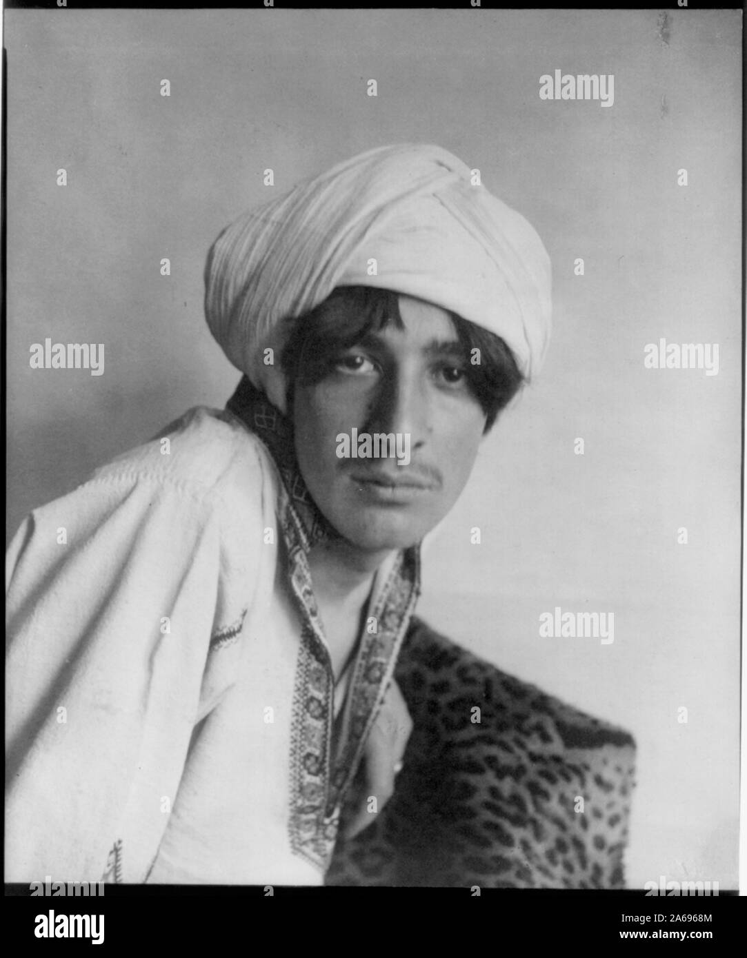 Junger Mann im Kostüm des Nahen Ostens, mit Turban und Leopard Haut, im Studio Stockfoto