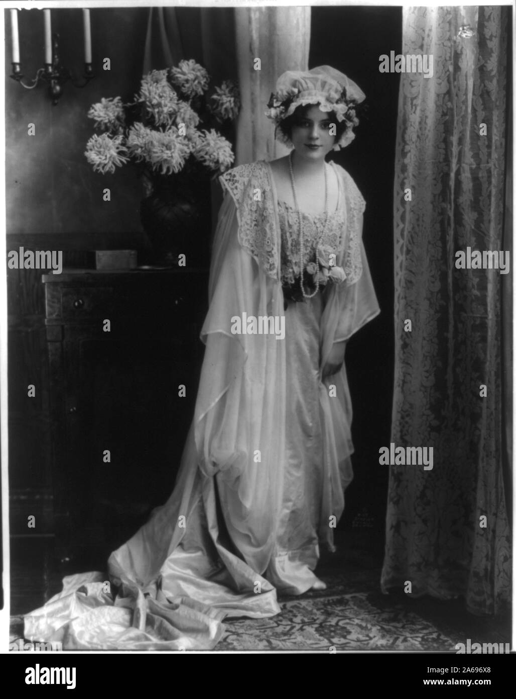 Junge Frau in Lace Kleid und Cap gestellt Stockfoto